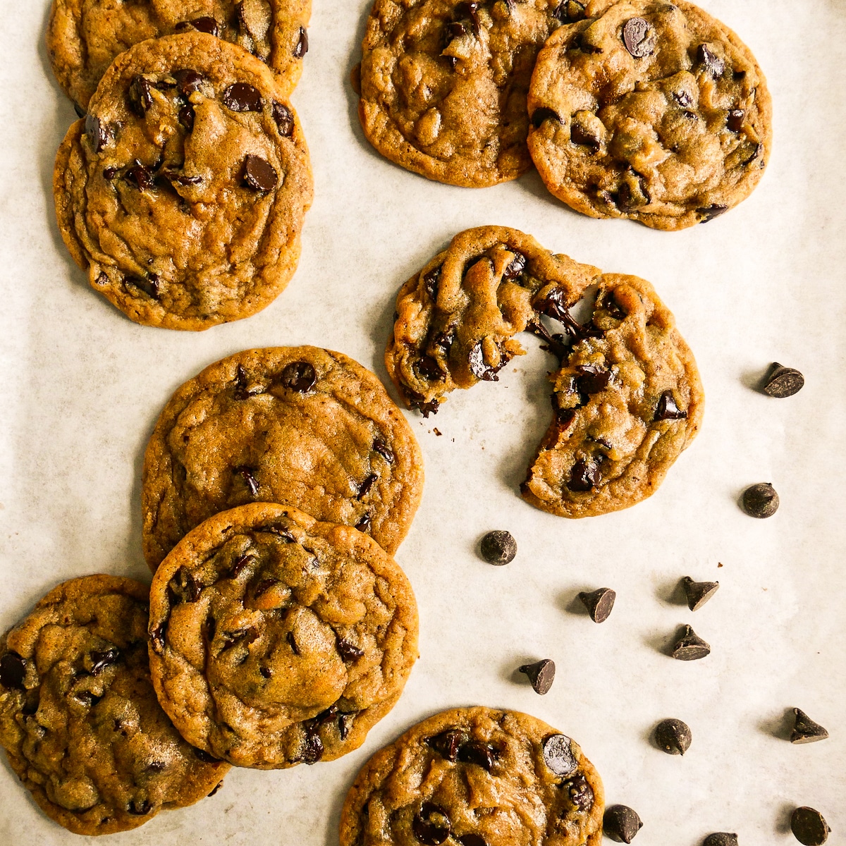 Rich and buttery chocolate chip cookies with brown butter laying on parchment.