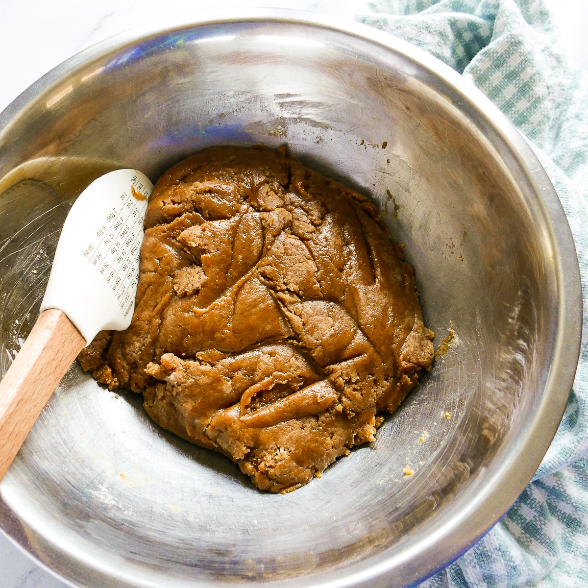 cookie dough combined in a bowl with rubber spatula.