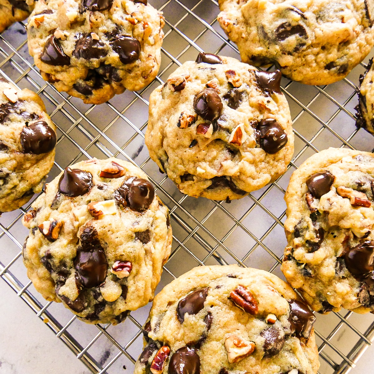 freshly baked thick and chewy cookies on a cooling rack.