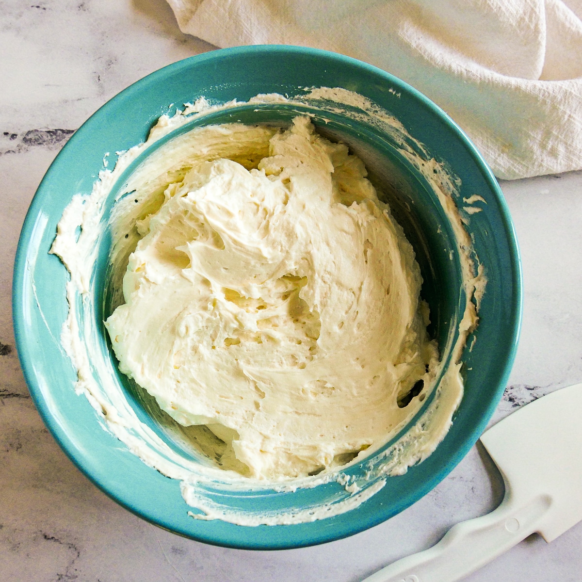 Light and fluffy whipped cream in a blue bowl.