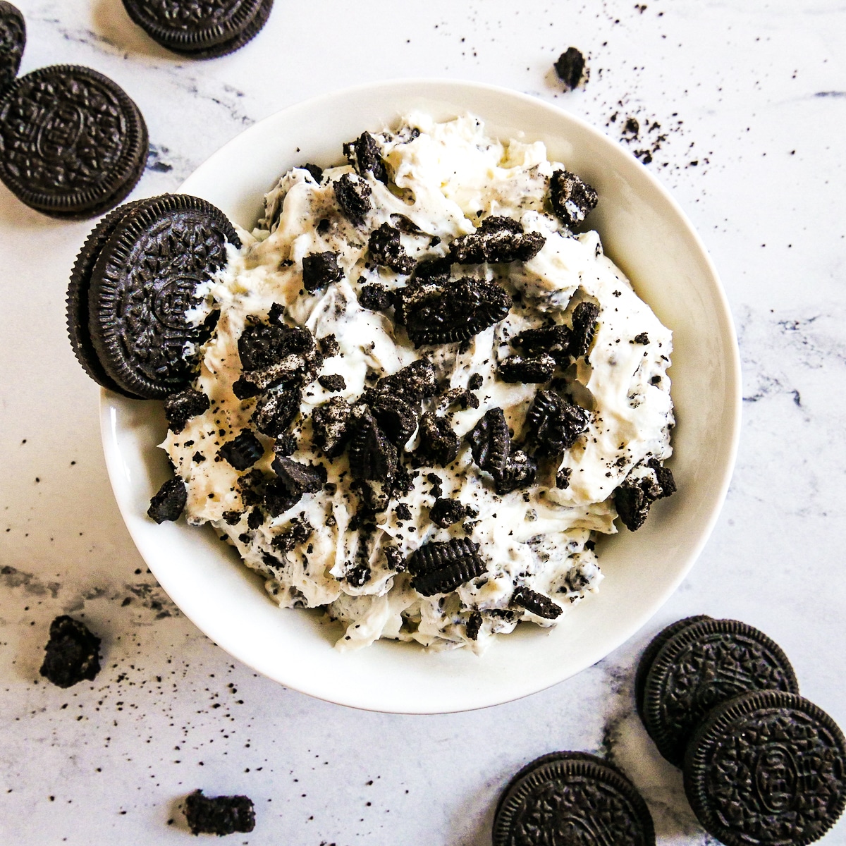 Creamy and rich cookies and cream dip in a small white bowl.