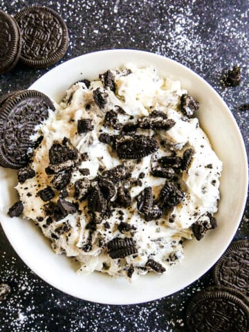 bowl of creamy oreo cookie dip topped with crushed oreos.