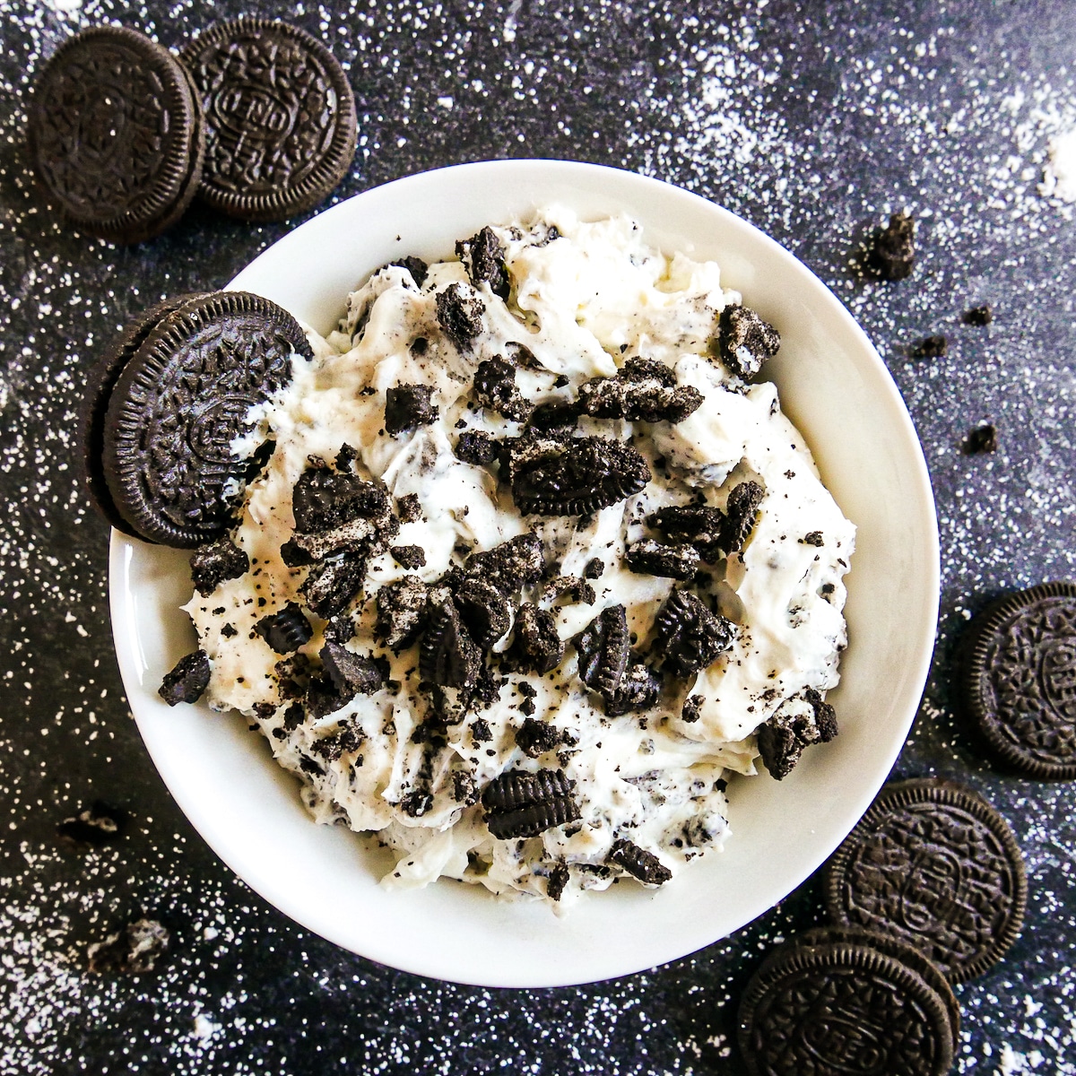 bowl of creamy oreo cookie dip topped with crushed oreos.
