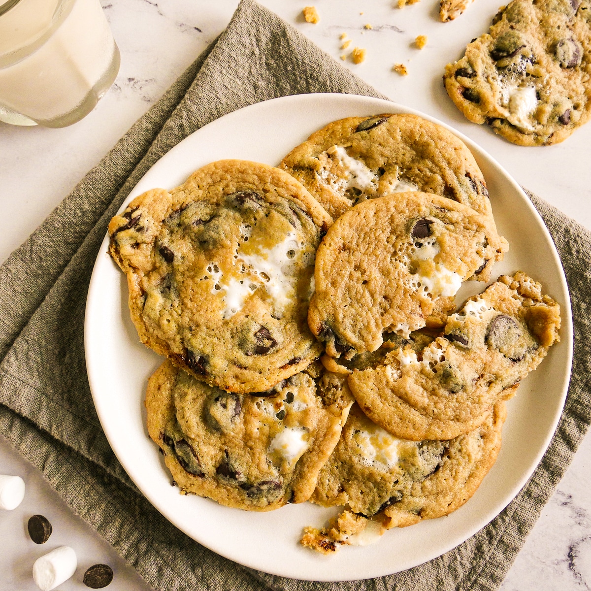 Gooey marshmallow chocolate chip cookies arranged on a white plate.