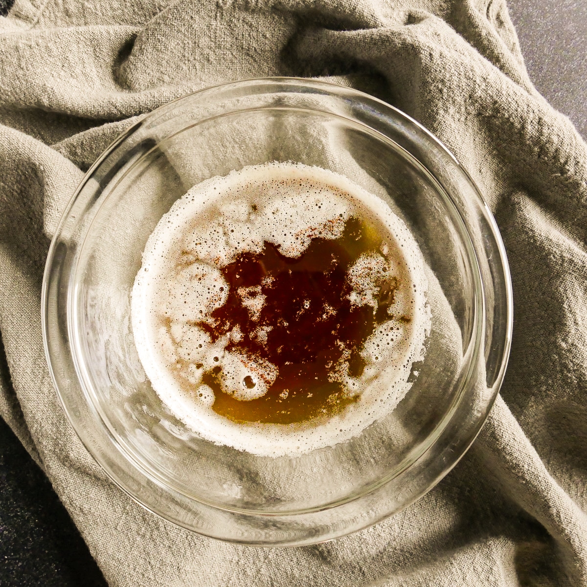 Foamy browned butter in a small glass bowl.