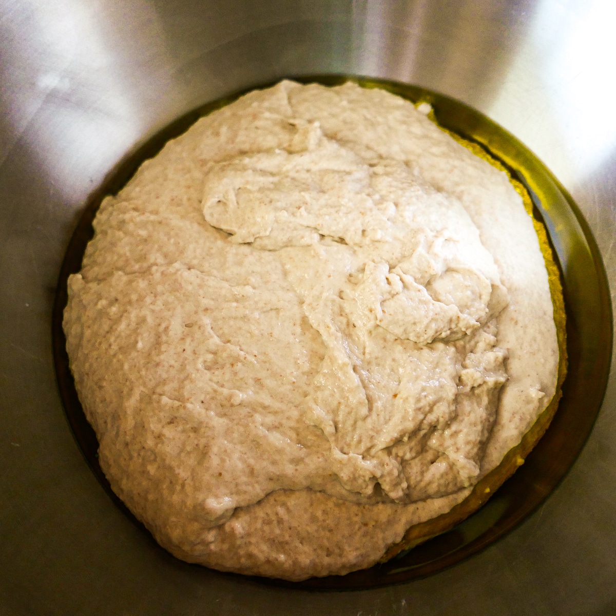 Focaccia dough transferred to an oiled mixing bowl to rise.