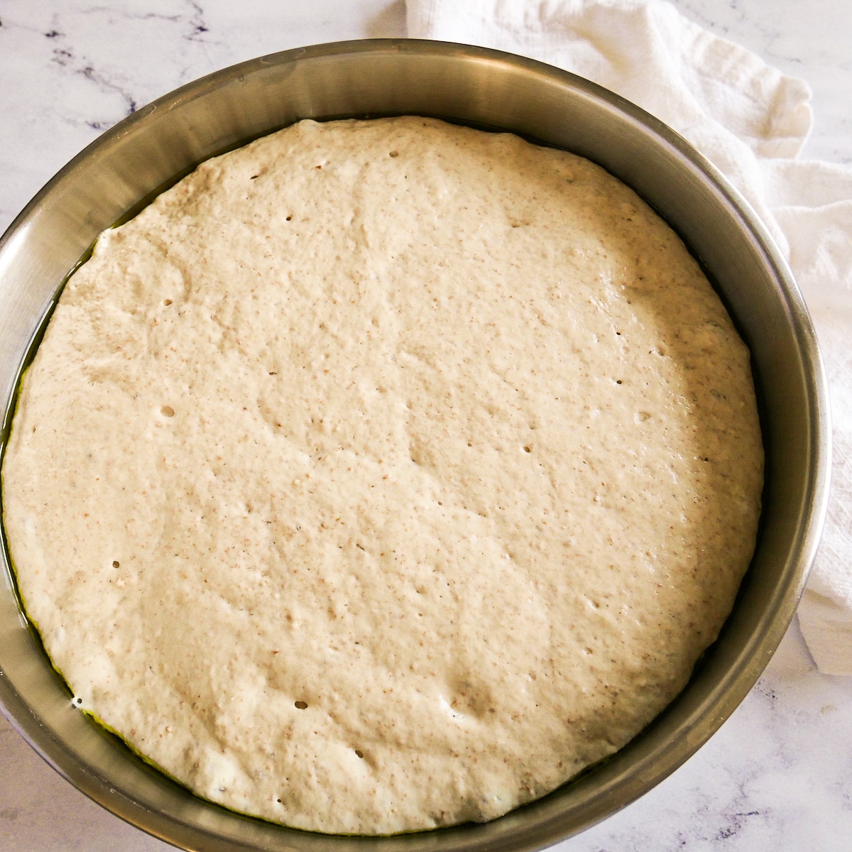 Focaccia dough in a mixing bowl after doubling in volume.