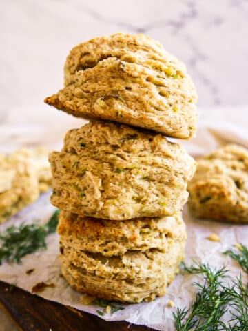 Fluffy potato biscuits stacked on parchment paper.