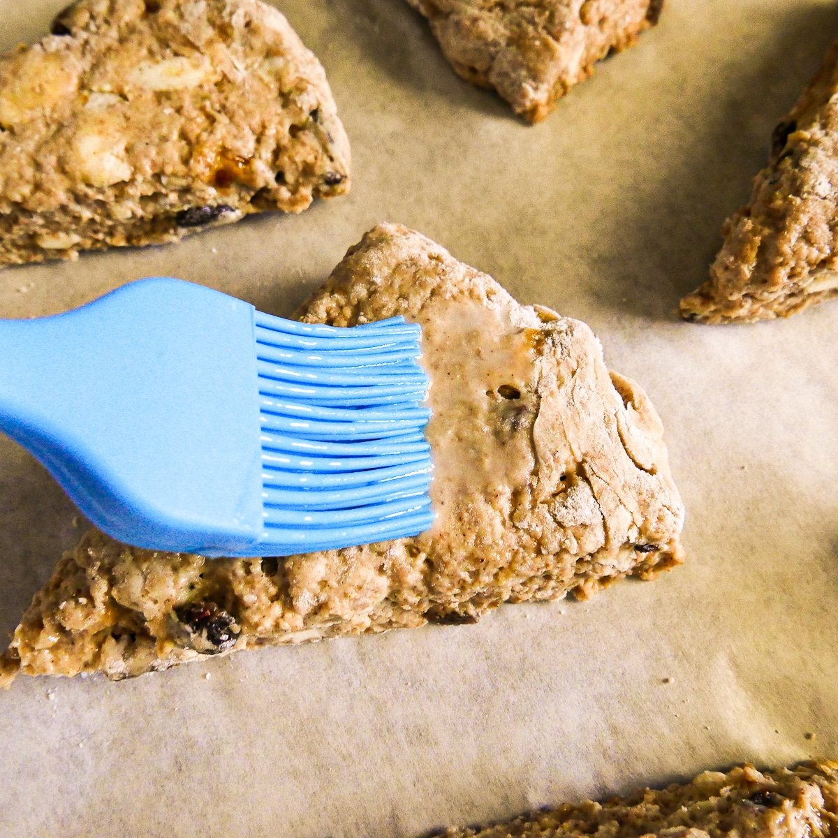 Brushing milk on top of scones before going into the oven. 