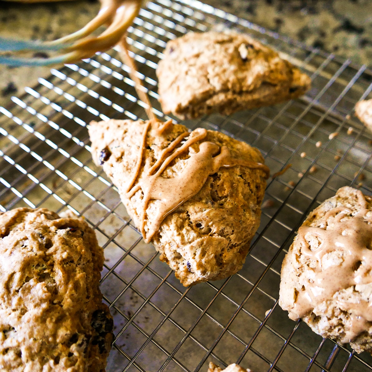 Drizzling glaze on cooled scones.