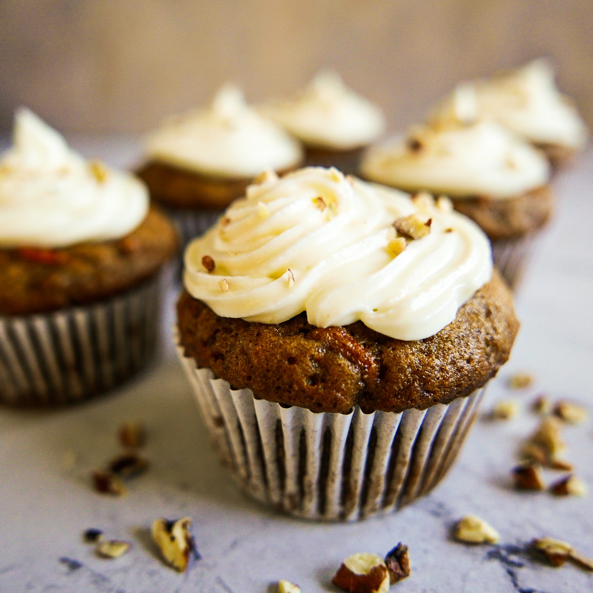 Fluffy carrot cake cupcakes arranged on a table.