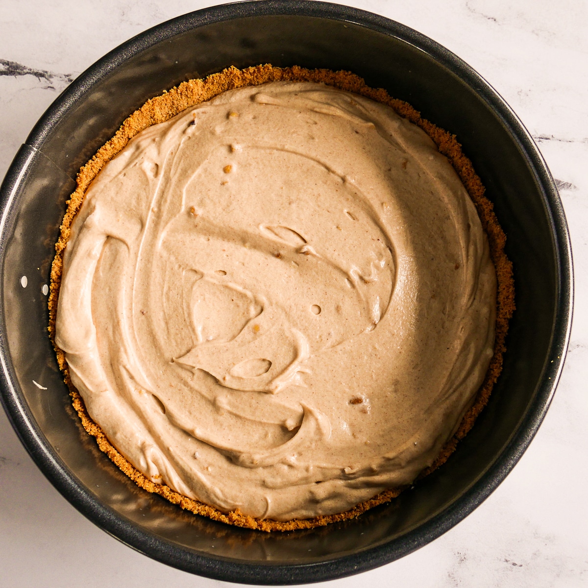 Assembled pie poured into prepared graham crust and topped with peanuts.