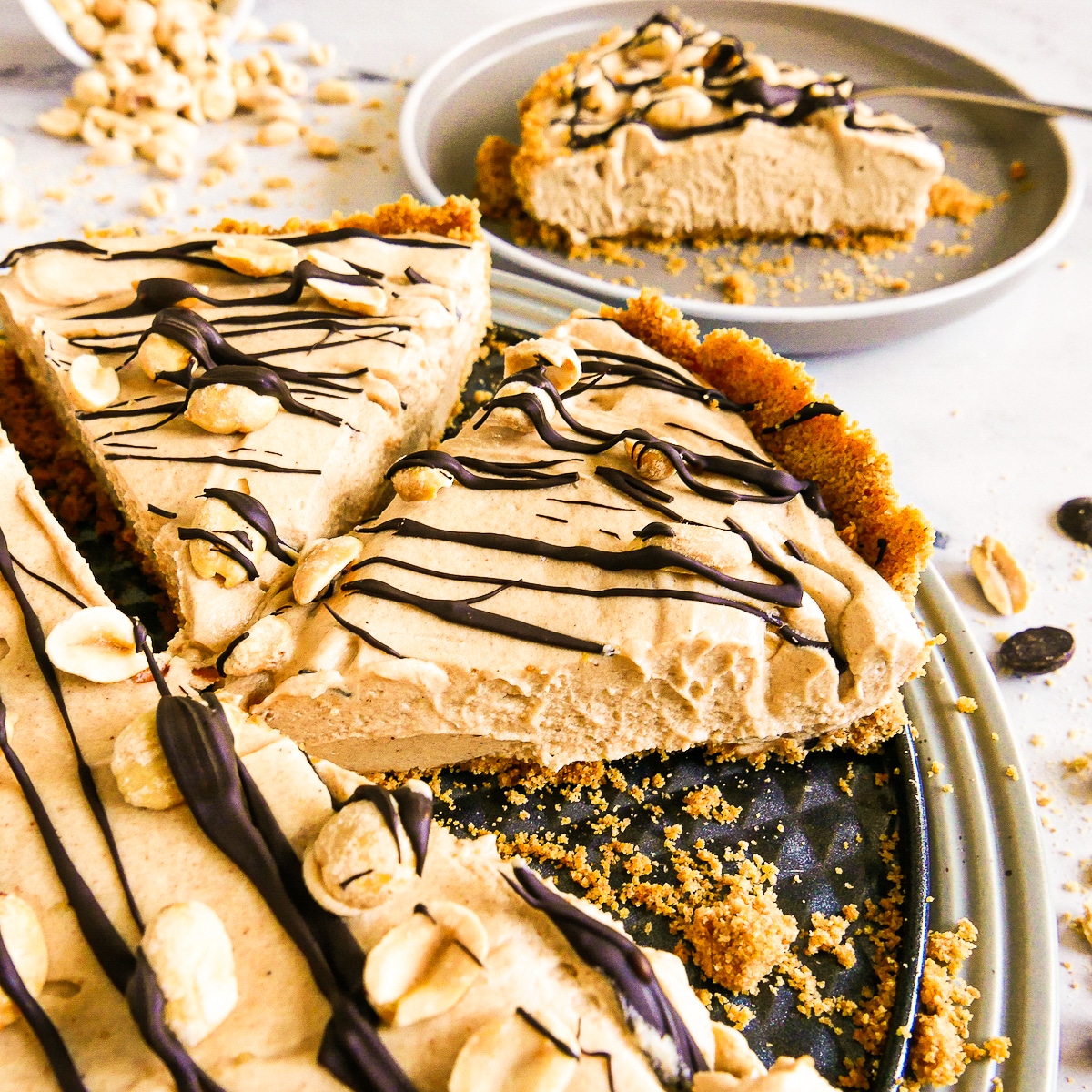 Slices of pie arranged on a platter with one plate in the background.