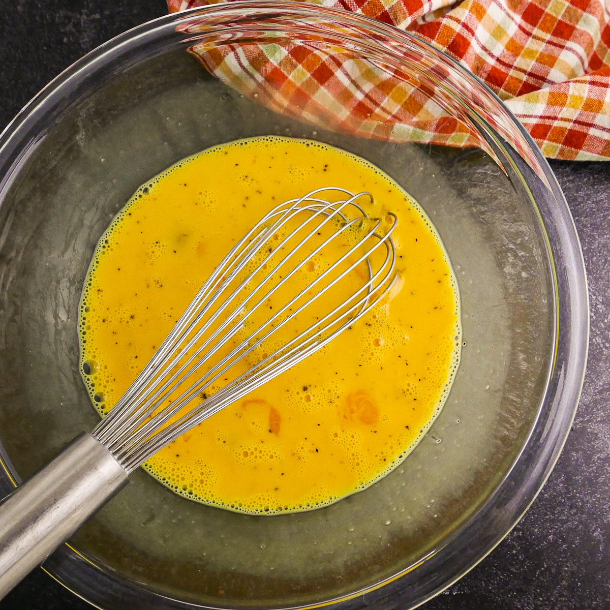 Whisked eggs in a large mixing bowl.