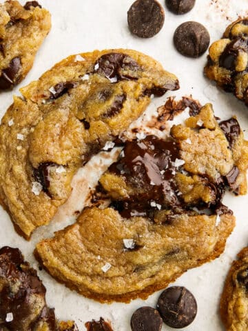 Chewy and crisp brown butter chocolate chip cookies arranged on parchment paper.