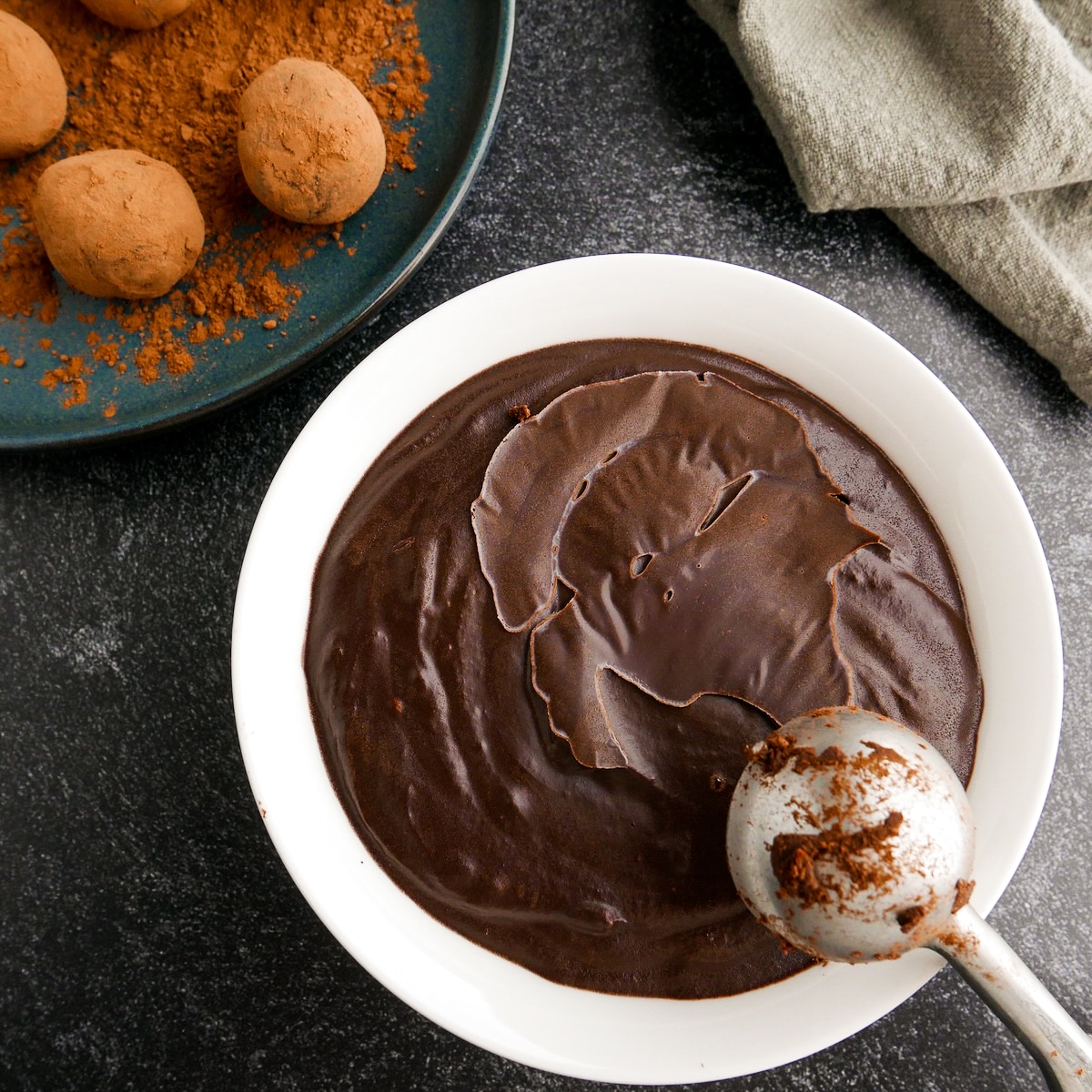 Bowl of chocolate ganache with a cookie scoop.