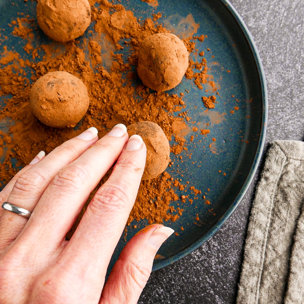 Rolling balls of chocolate ganache in cocoa powder.