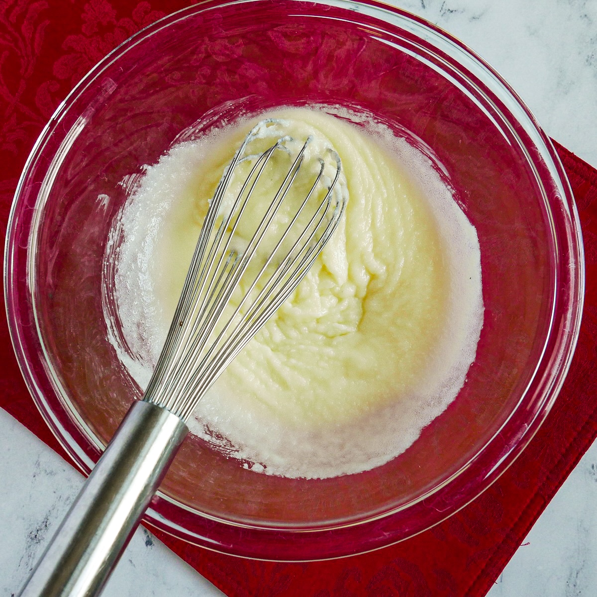 Granulated sugar whisked into a bowl of melted butter.