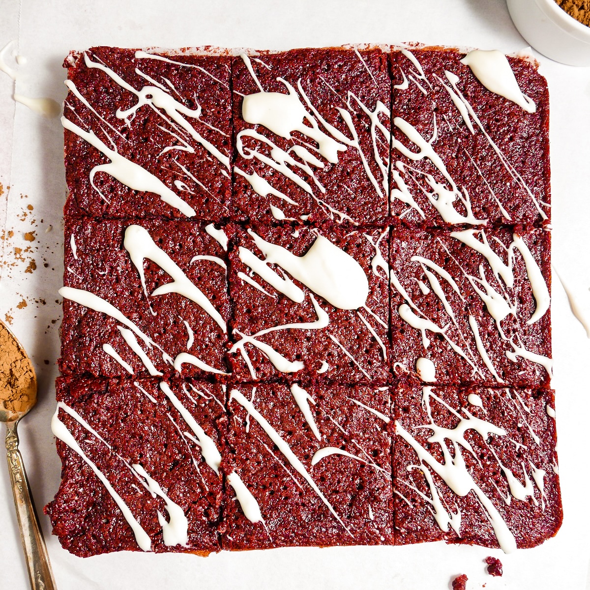 Sliced brownies drizzled with cream cheese glaze.