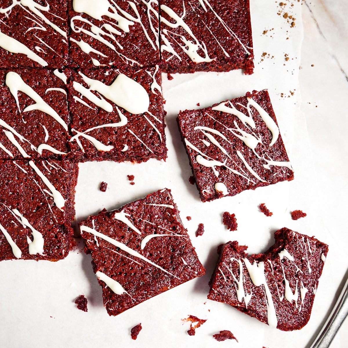 Chewy brownies cut into squares on parchment paper.