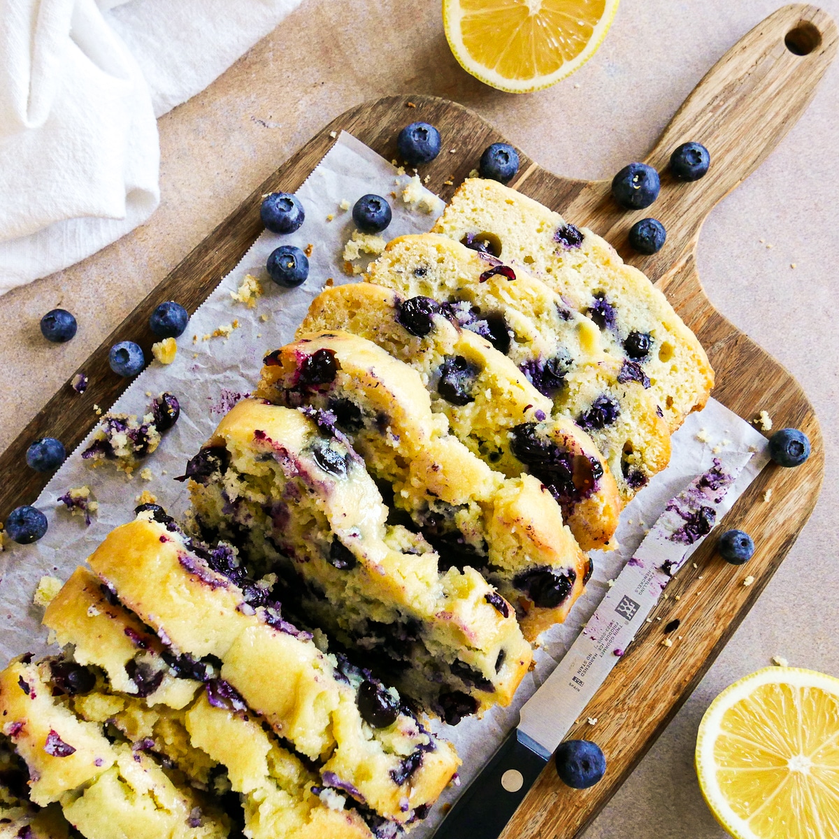 Ricotta pound cake sliced on a wooden cutting board with knife.
