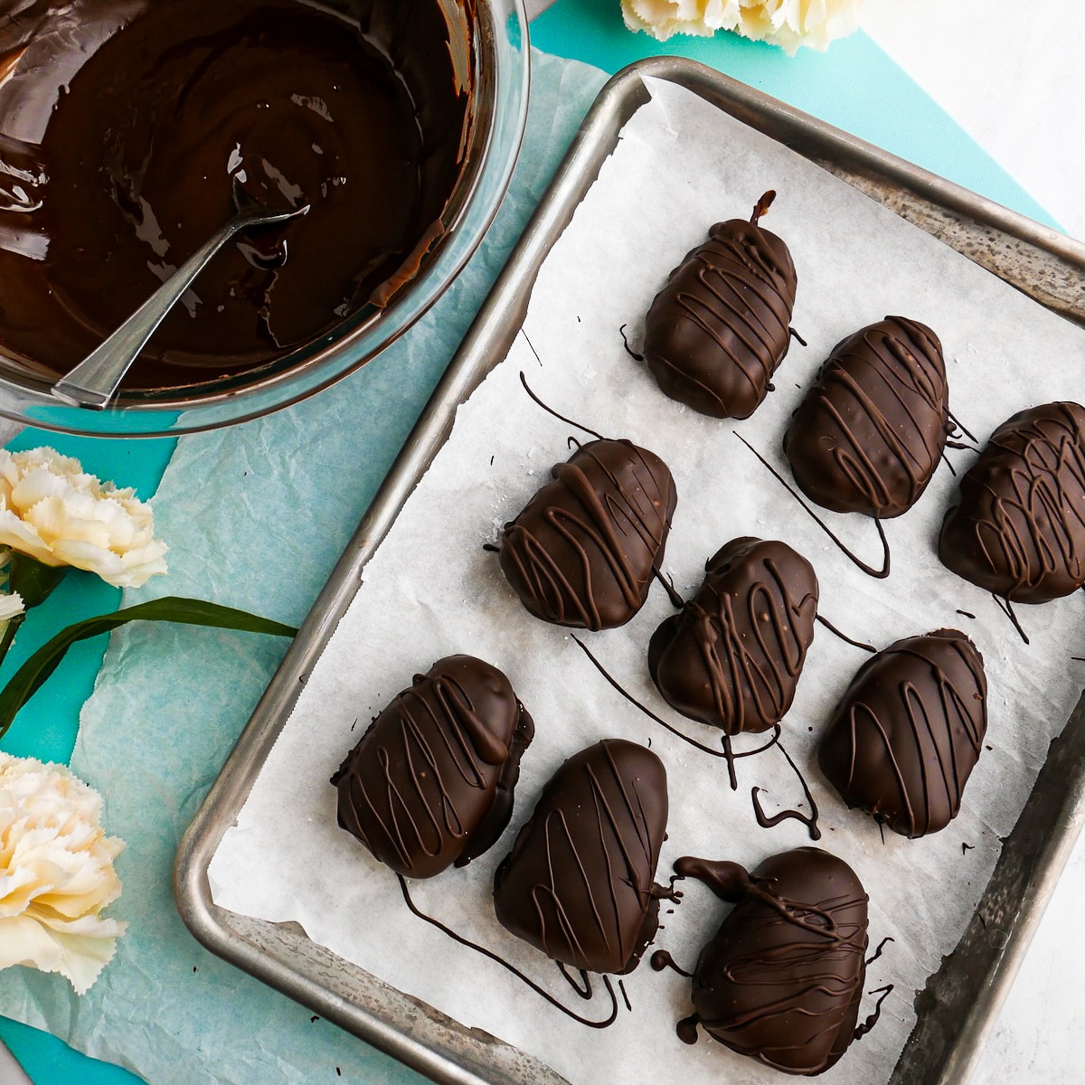 chocolate-dipped-cream-eggs.jpg Chocolate dipped coconut cream eggs arranged on a parchment lined baking sheet.