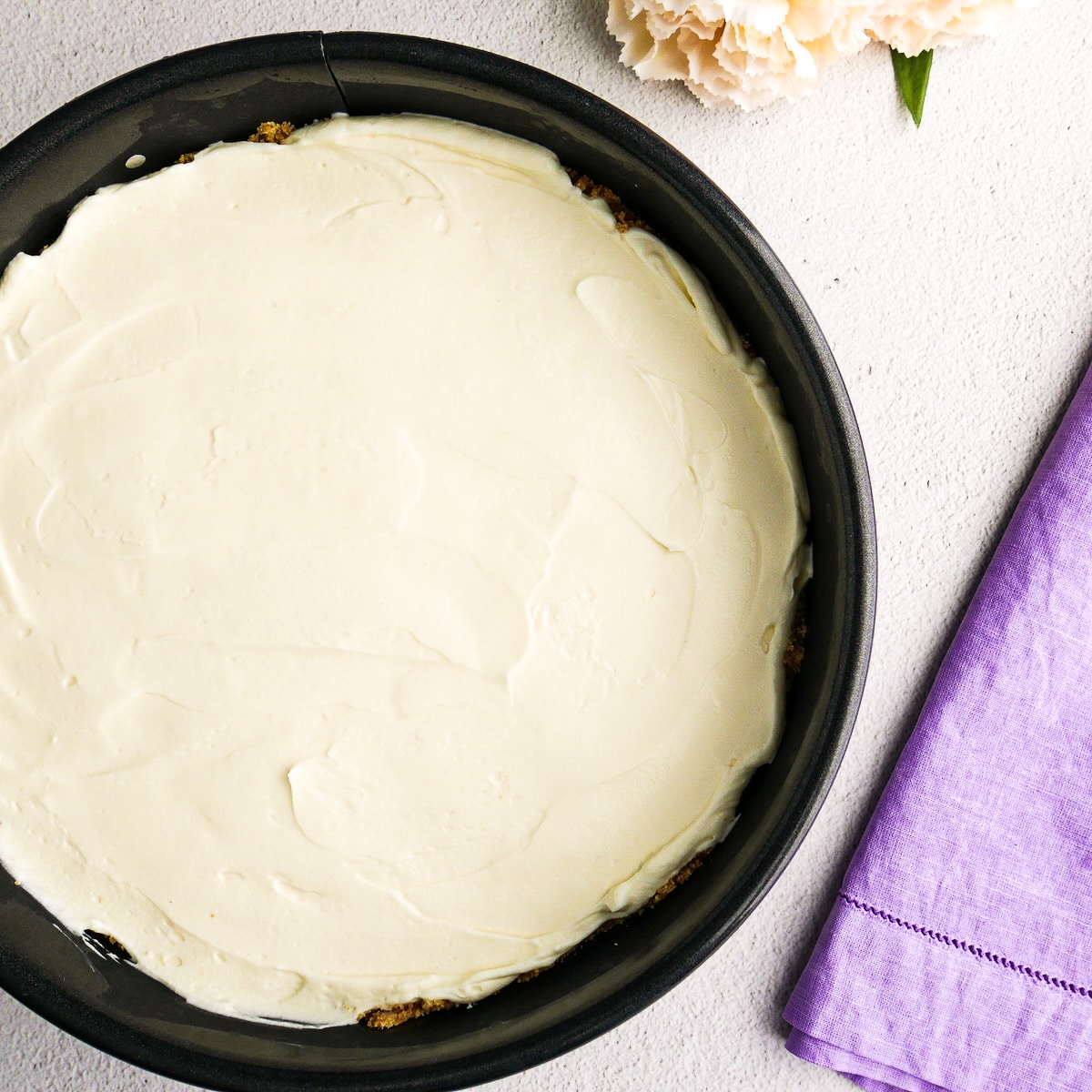 Cheesecake filling poured into prepared graham crust.