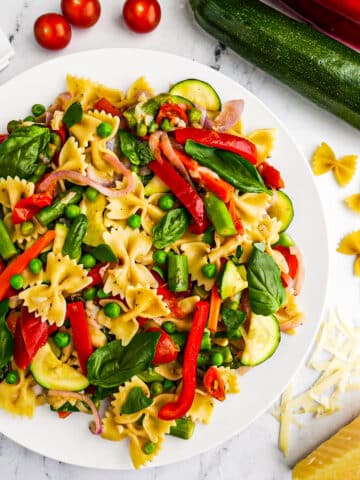 Easy pasta primavera served on a plate with fresh basil.