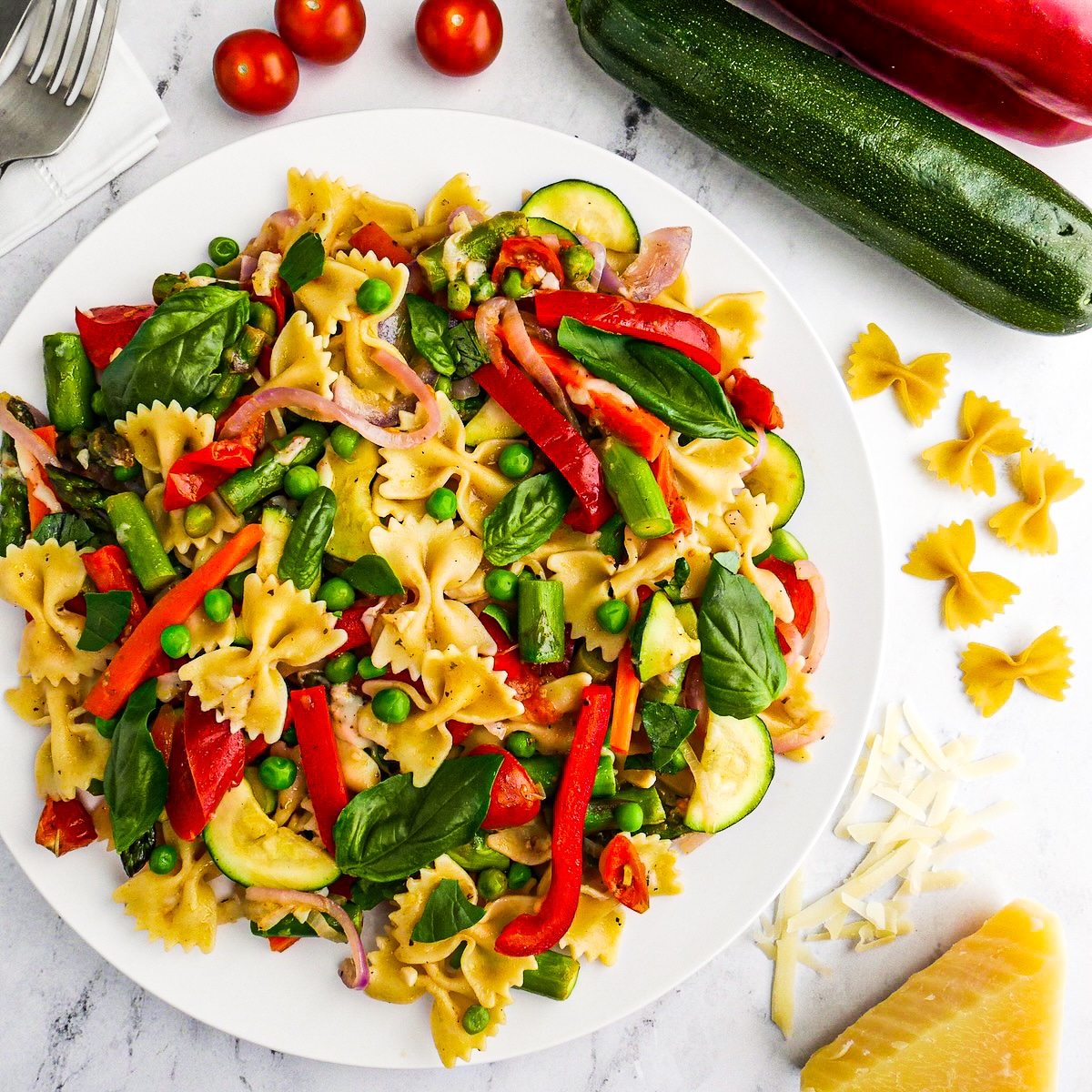 Easy pasta primavera served on a plate with fresh basil.