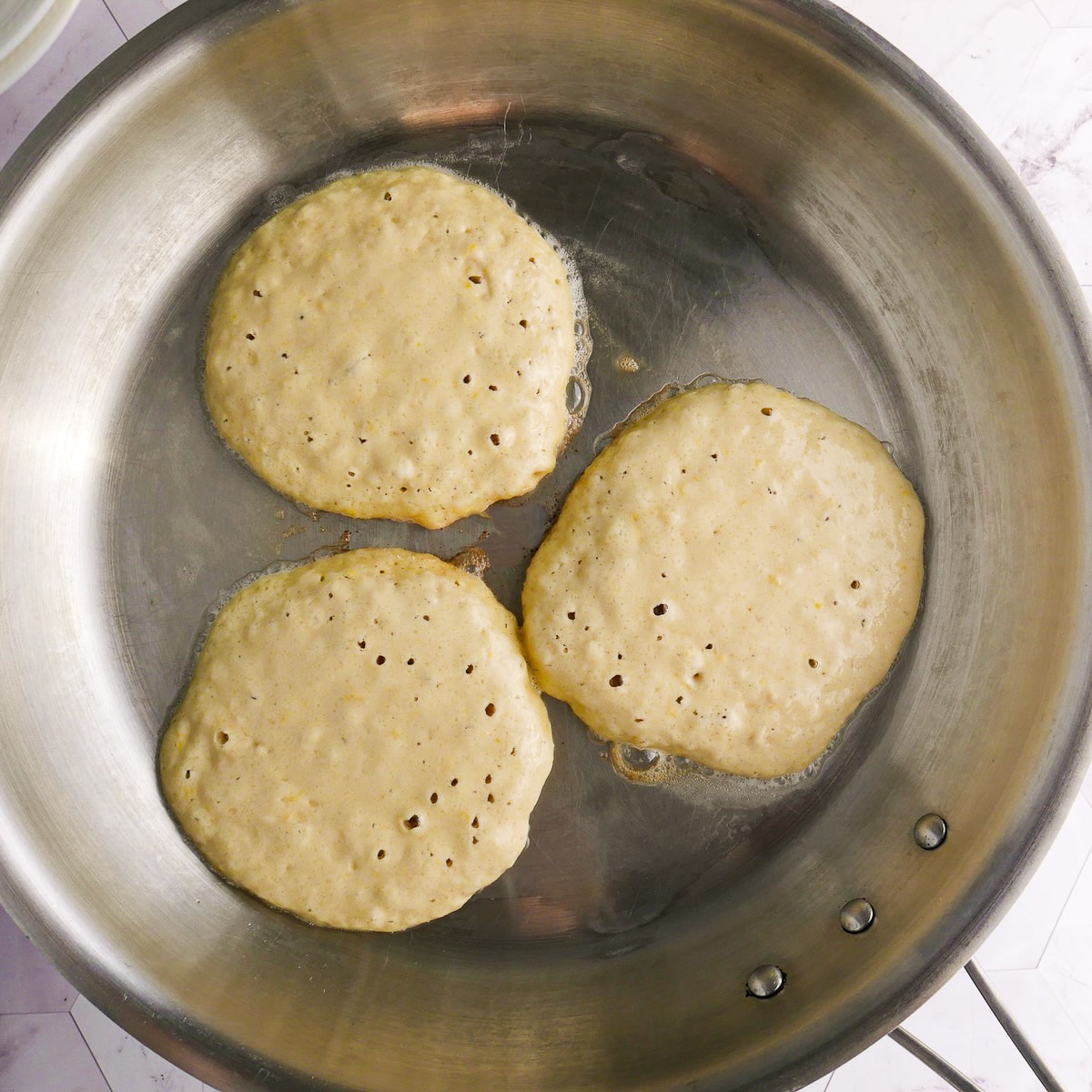 bubbling-pancakes.jpg Pancakes bubbling up in a large skillet.