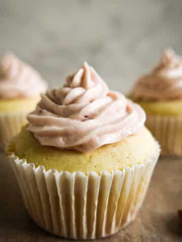 almond cupcakes arranged on a table with toasted almonds.