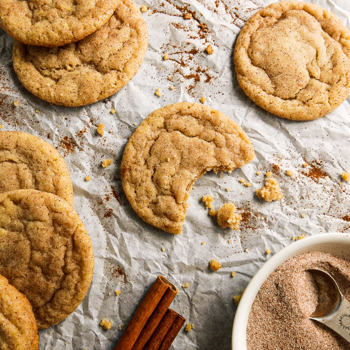 Soft brown butter cookies arranged on parchment with cinnamon and sugar. 