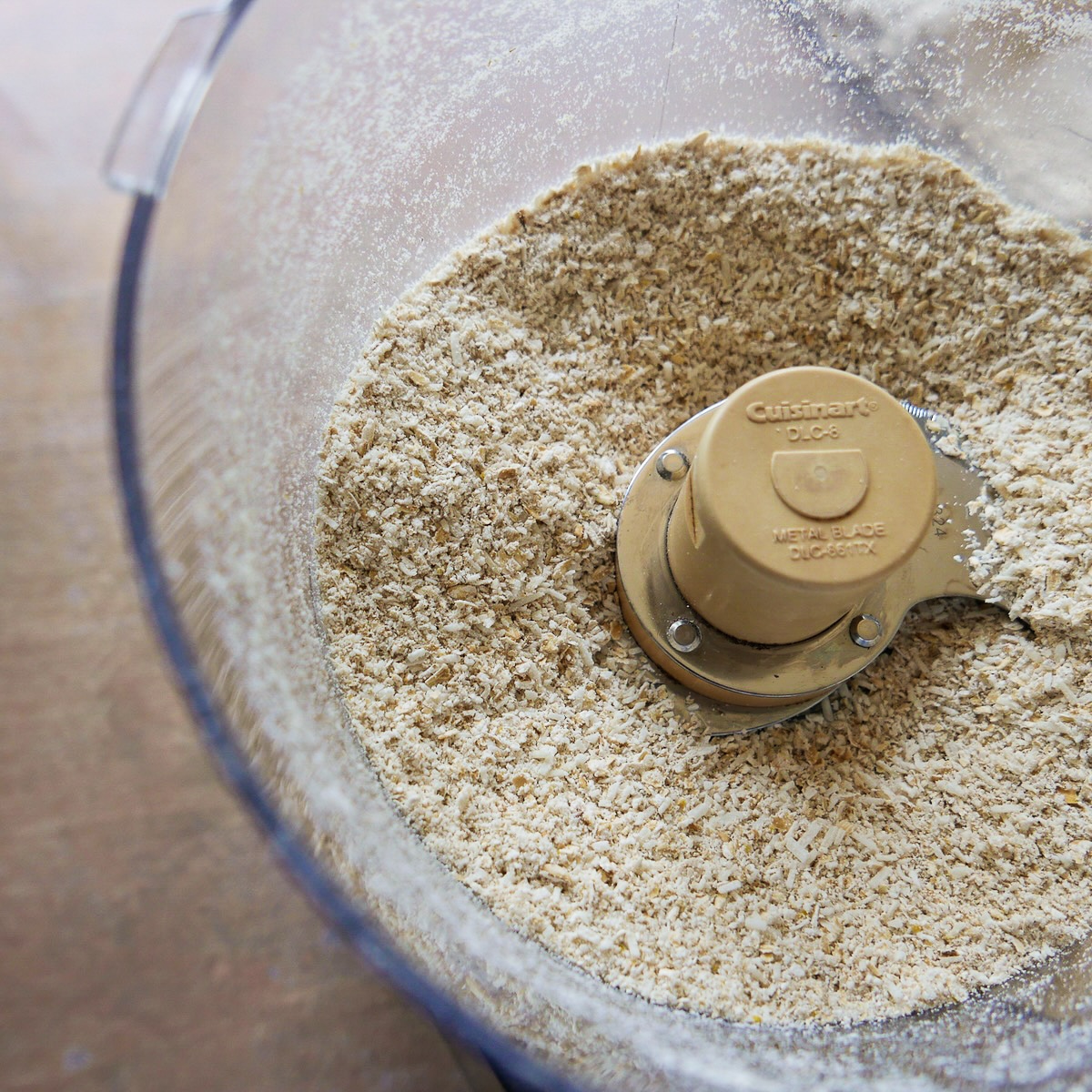 Rolled oats and unsweetened coconut in a food processor.