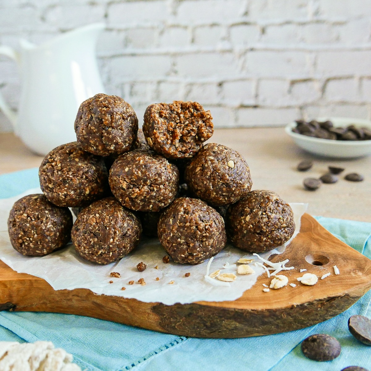 Energy balls stacked in a pile on parchment paper.