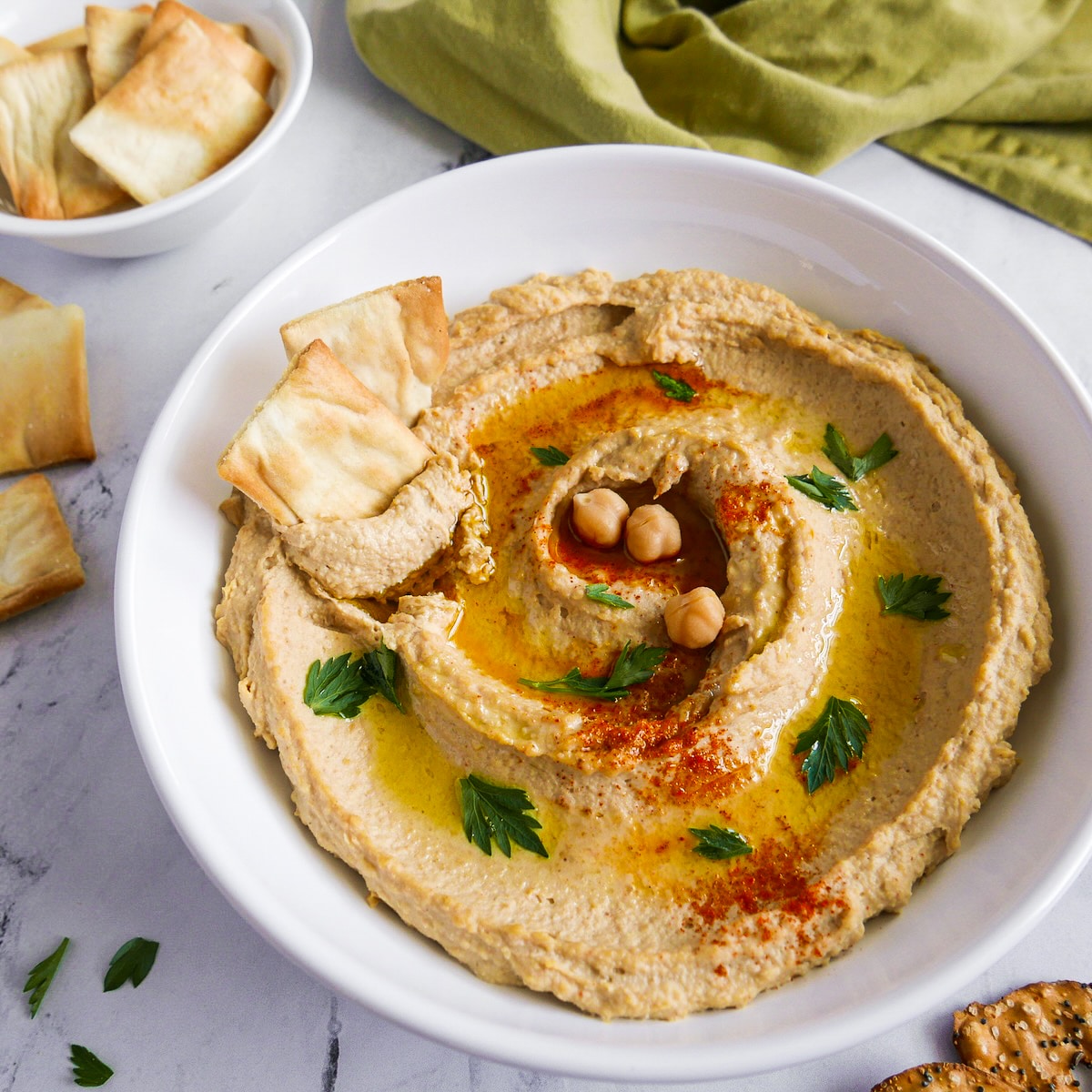 Smoky hummus garnished with parsley and olive oil.