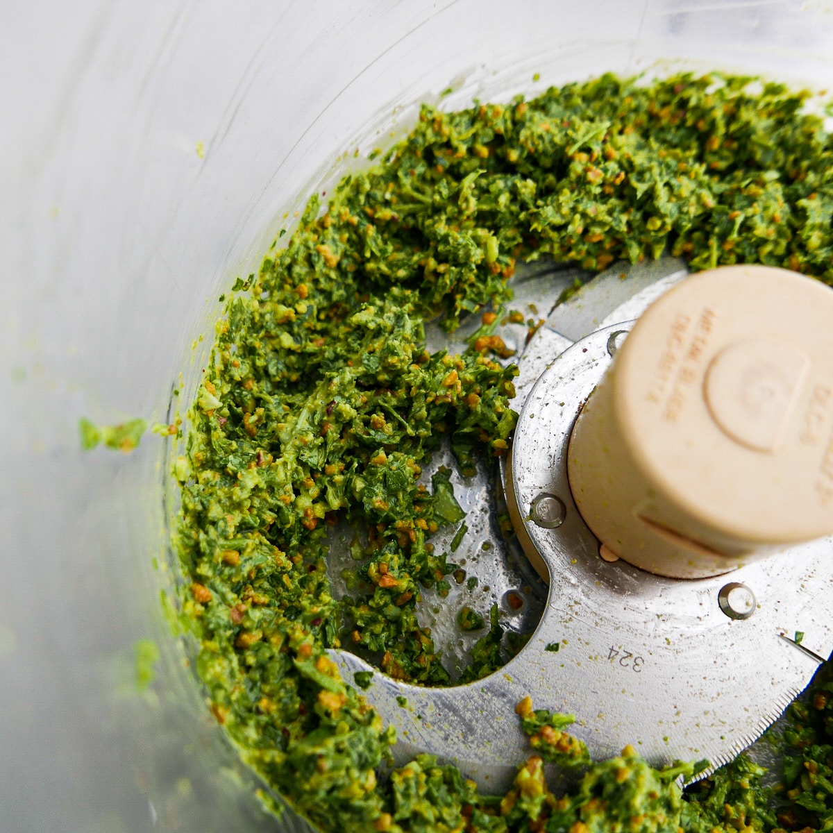 Blended pesto ingredients in a food processor.