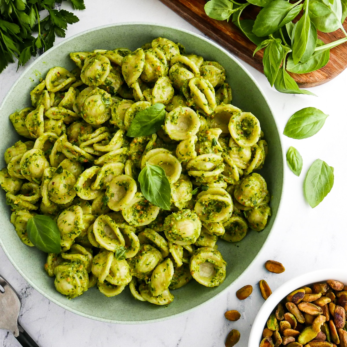 Pistachio pesto mixed into a bowl of pasta.