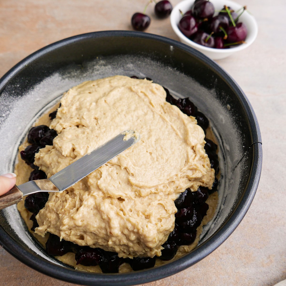 Cake batter spread on top of cherry filling in prepared pan.