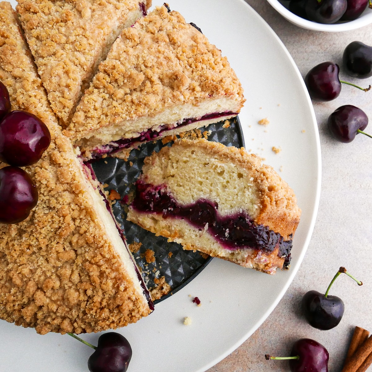 Moist cherry coffee cake sliced on a platter.