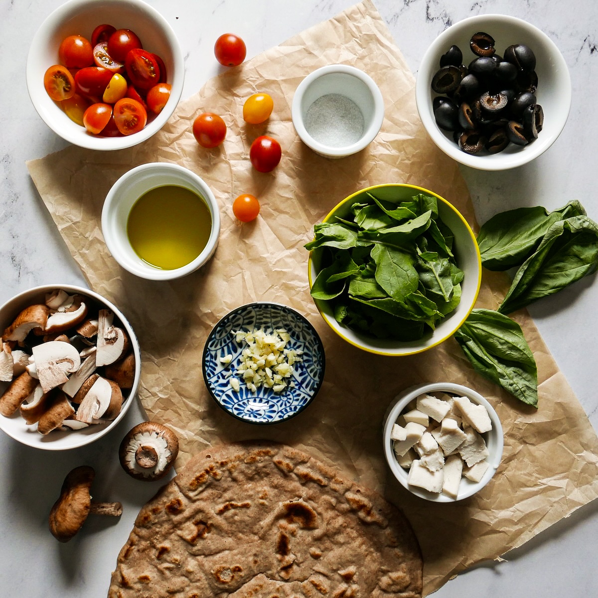 Pizza ingredients arranged on a table.