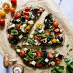 Crispy vegan flatbread pizza topped with basil.