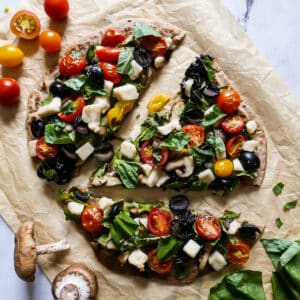 Crispy vegan flatbread pizza topped with basil.