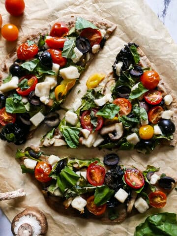 Crispy vegan flatbread pizza topped with basil.
