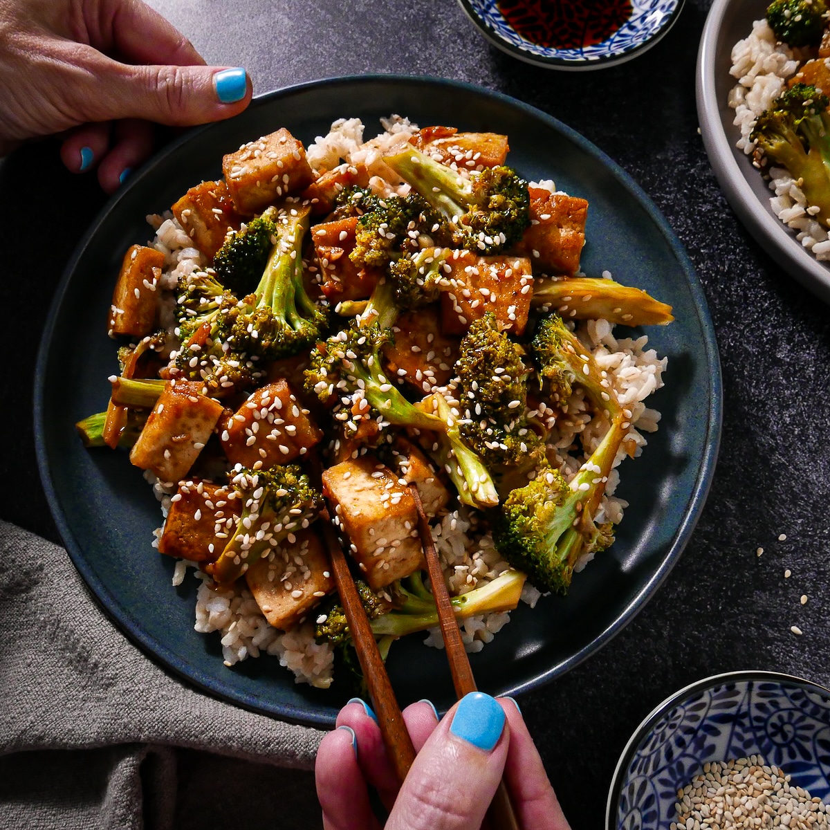 tofu-stir-fry.jpg Broccoli and tofu stir fry being eaten with chopsticks.