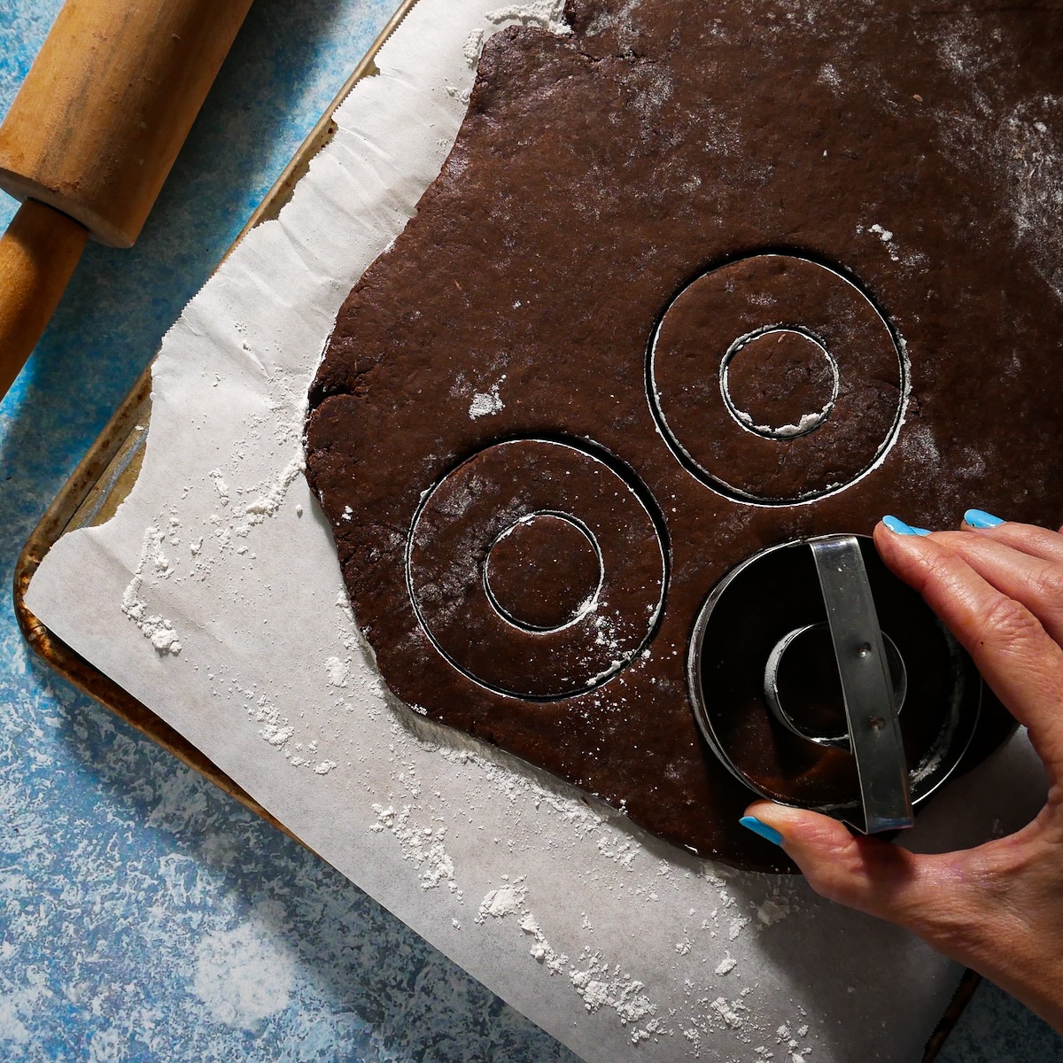 Cutting donuts out with a donut cutter. 