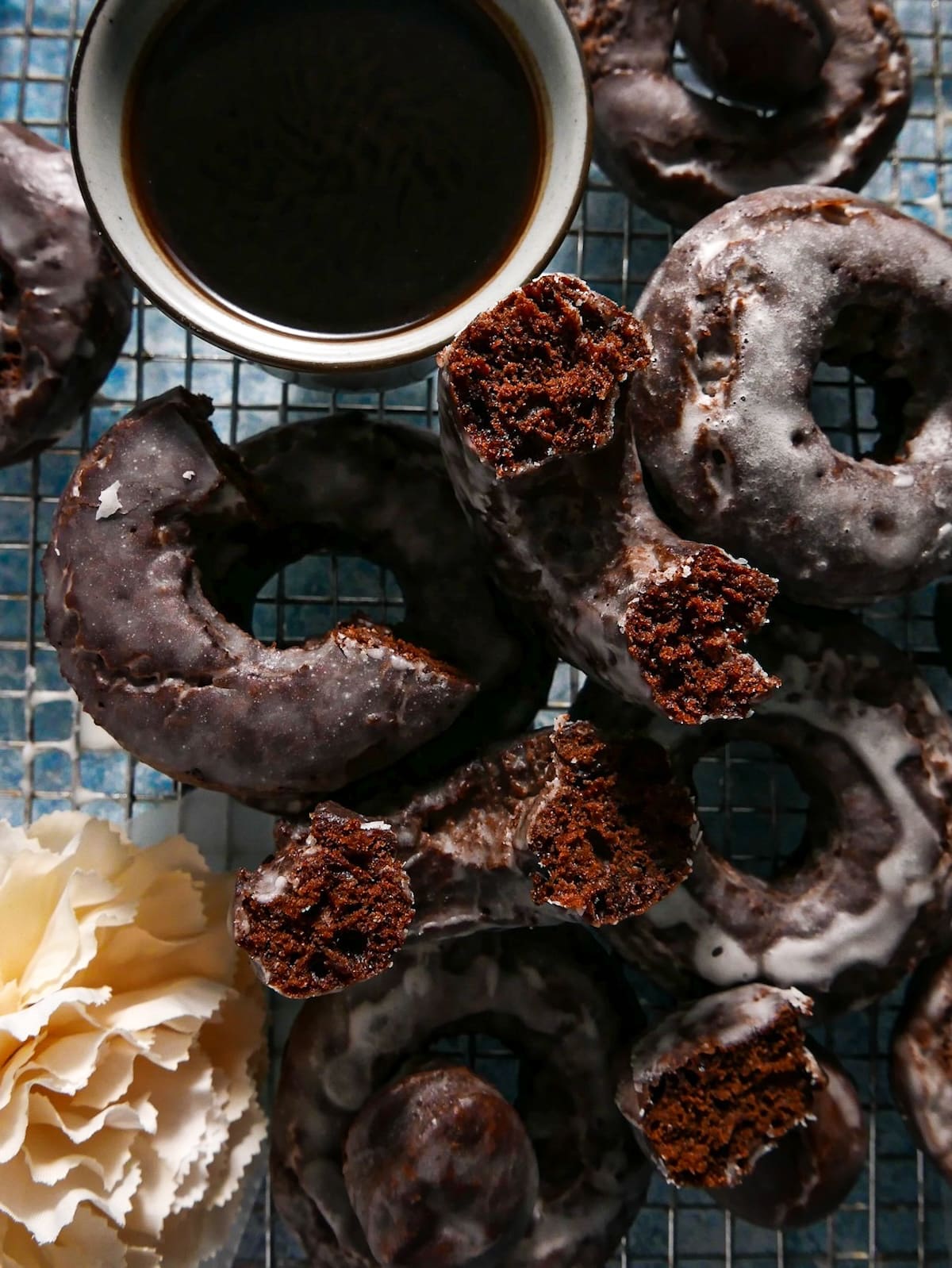 Old fashioned donuts stacked on top of a wire rack.