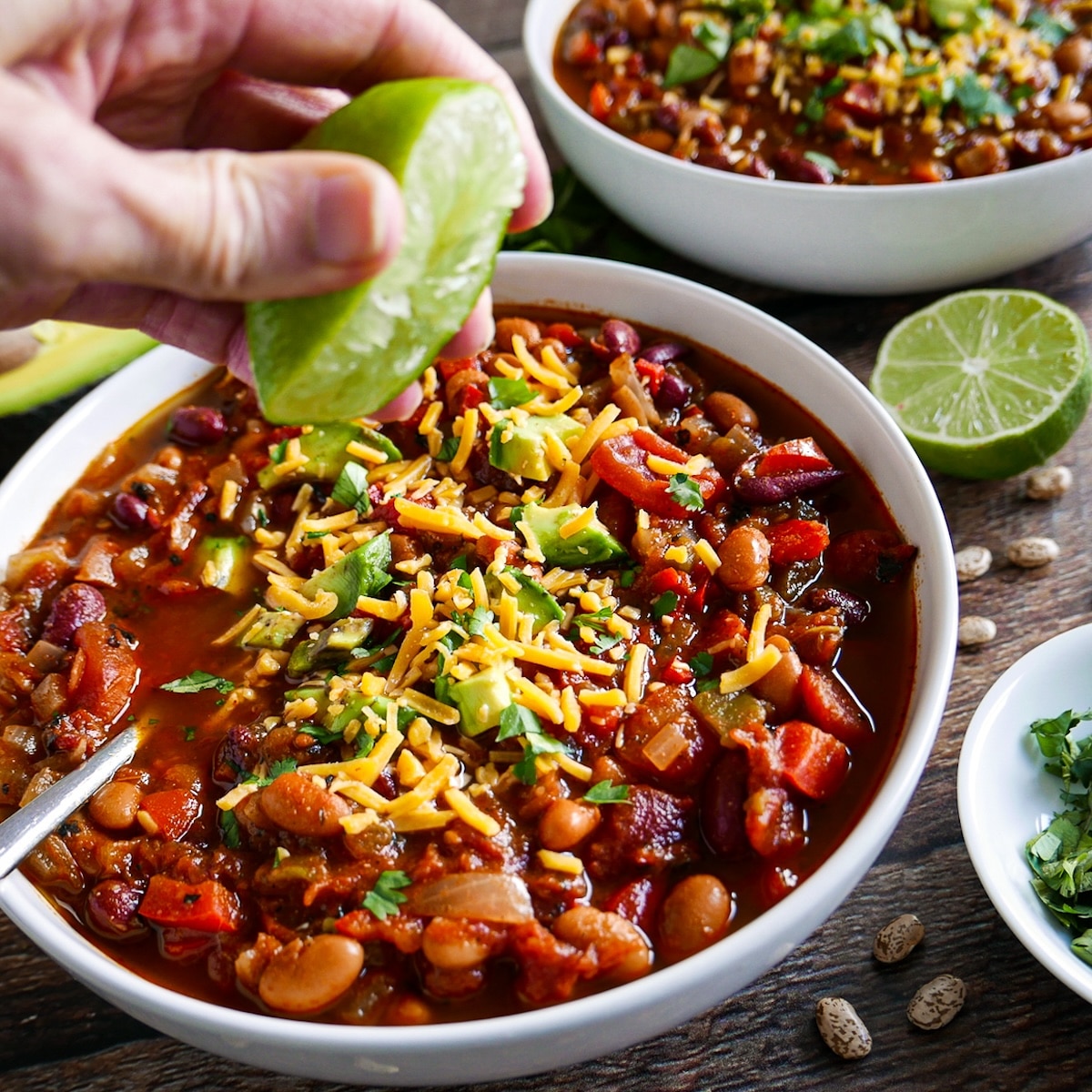 Squeezing lime over bowl of meatless chili.