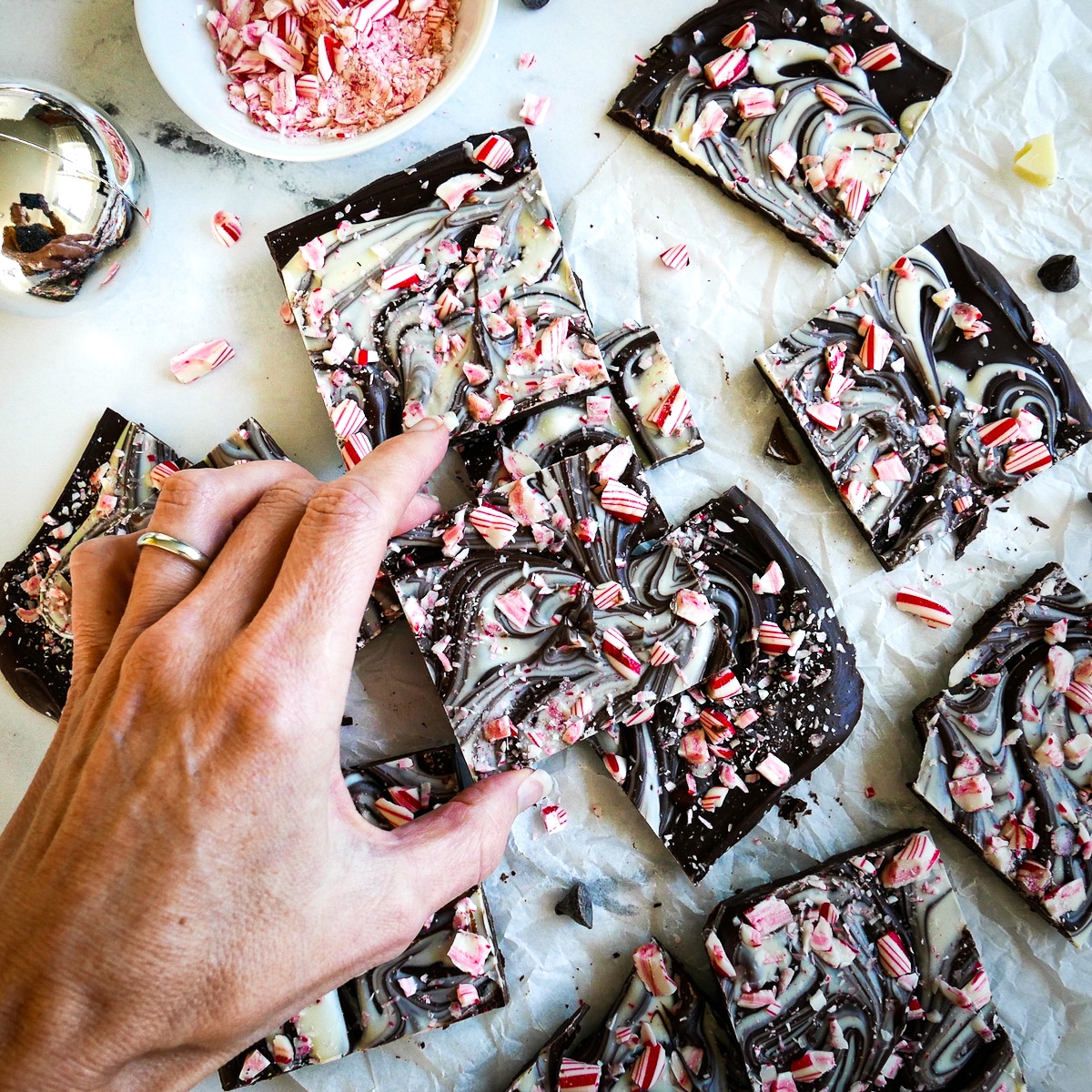 Picking up piece of homemade peppermint bark.