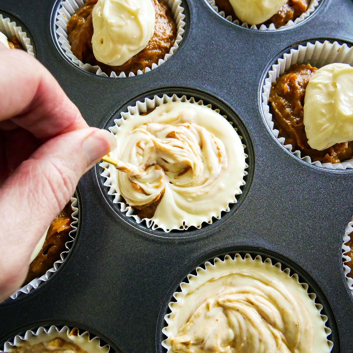 swirling-cream-cheese.jpg Using a toothpick to swirl cream cheese mixture into muffin batter.