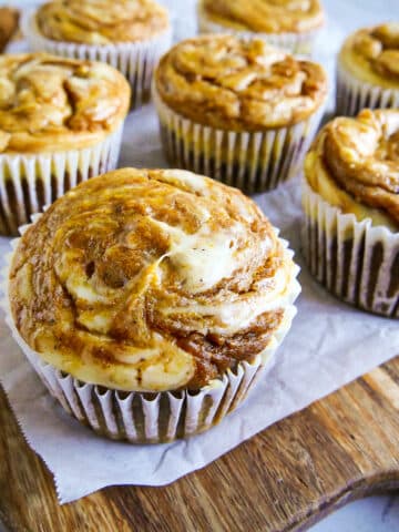 Easy pumpkin cream cheese muffins arranged on a cutting board.